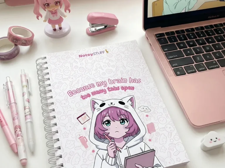 NoteyStuff A5 spiral notebook styled on a desk with pens and stickers